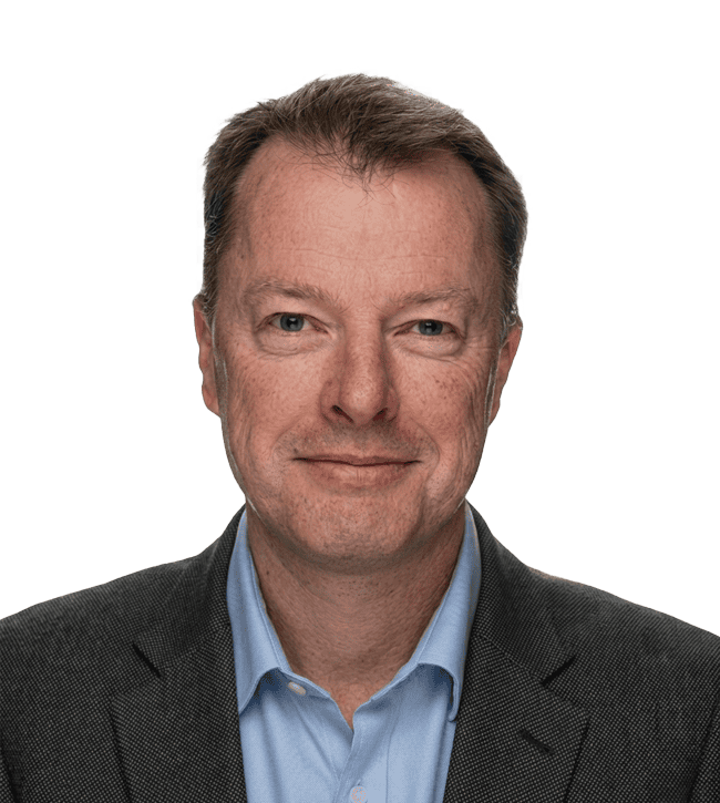 Professional headshot of a middle-aged man in a dark blazer and light blue shirt, smiling subtly, against a neutral backdrop.
